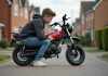 Les critères influençant le prix d’une moto de 50 cm³ : ce qu’il faut savoir Jeune garçon en jeans et hoodie inspectant sa moto 50cc dehors